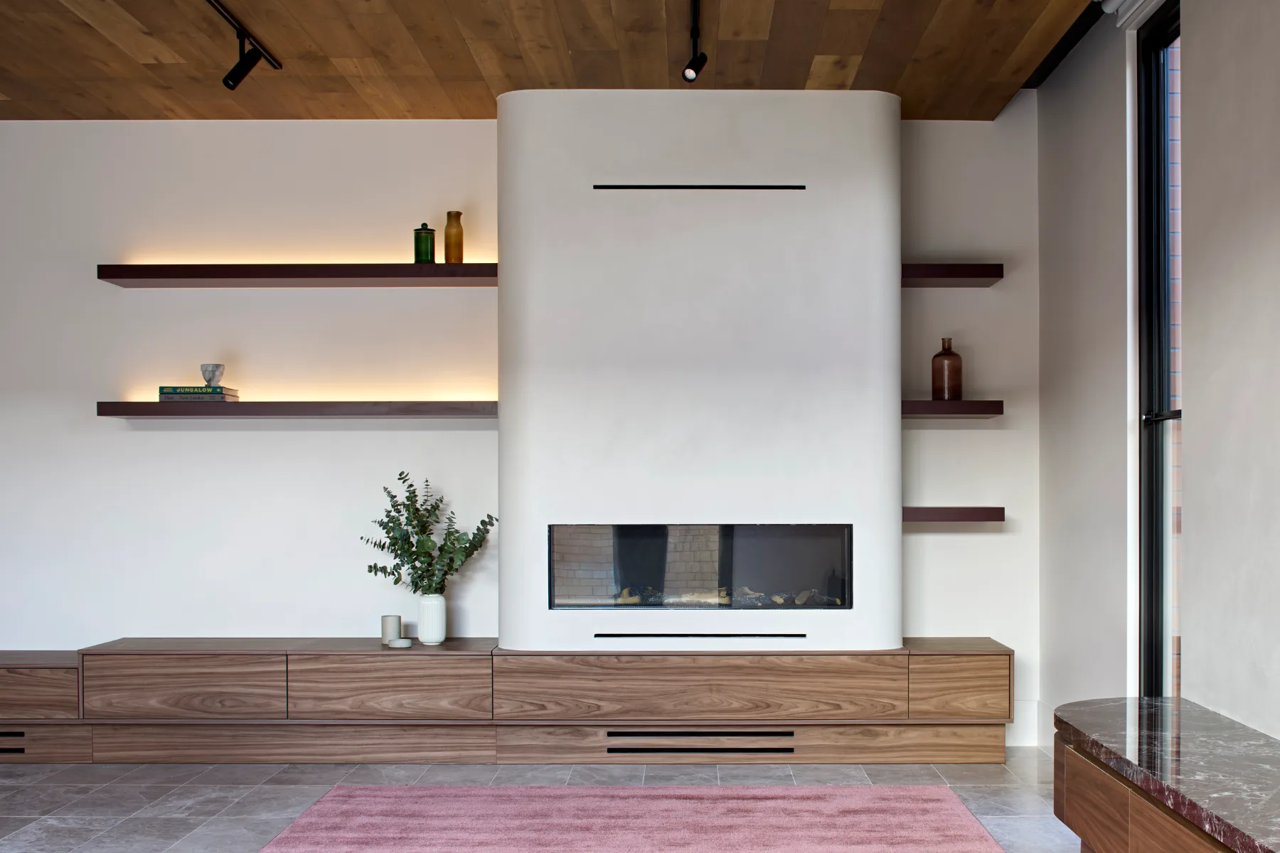 Caulfield. Living room with the fireplace and shelving.